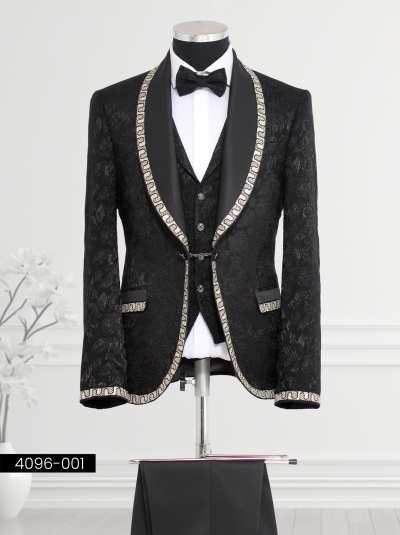 Elegant black brocade tuxedo featuring gold chain trim on the satin shawl lapel and cuffs, paired with tailored trousers and matching waistcoat.
