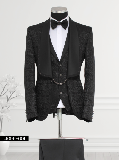 Black brocade tuxedo for men featuring intricate paisley patterns and a satin shawl lapel paired with tailored trousers and a bow tie.