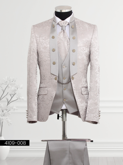 Silver tuxedo featuring floral brocade patterns, wide lapel design with decorative buttons, double-breasted waistcoat with silver buttons and chain detail, and matching trousers.