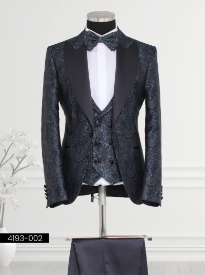 Men’s navy blue suit with satin lapels, paisley vest, and bow tie, ideal for formal occasions.