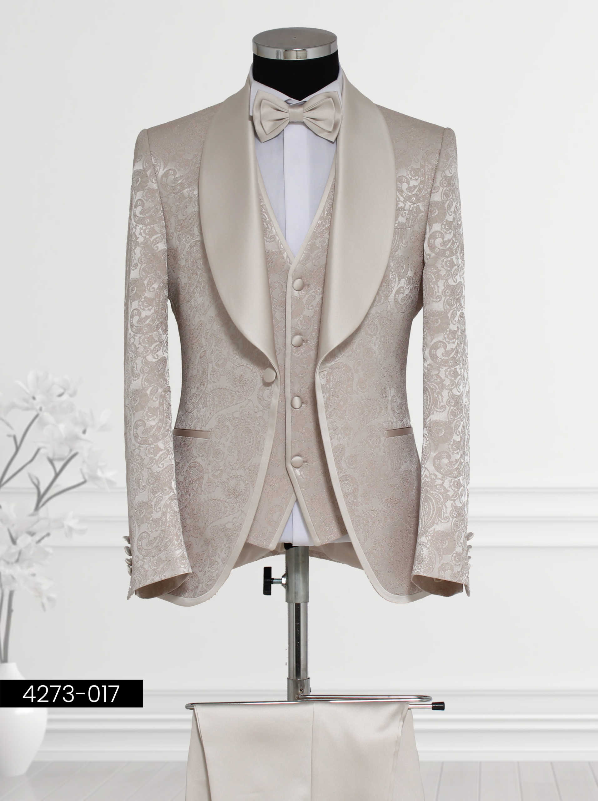 Men’s beige wedding suit with satin lapels, paisley vest, and bow tie