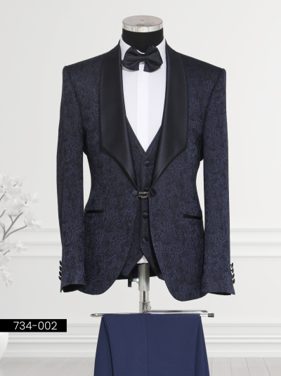 A stylish navy blue tuxedo with a patterned jacket, shirt, and bow tie displayed on a mannequin.