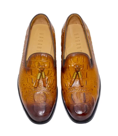 Elegant brown shoes with crocodile skin texture, gold-accented tassels, and polished design.