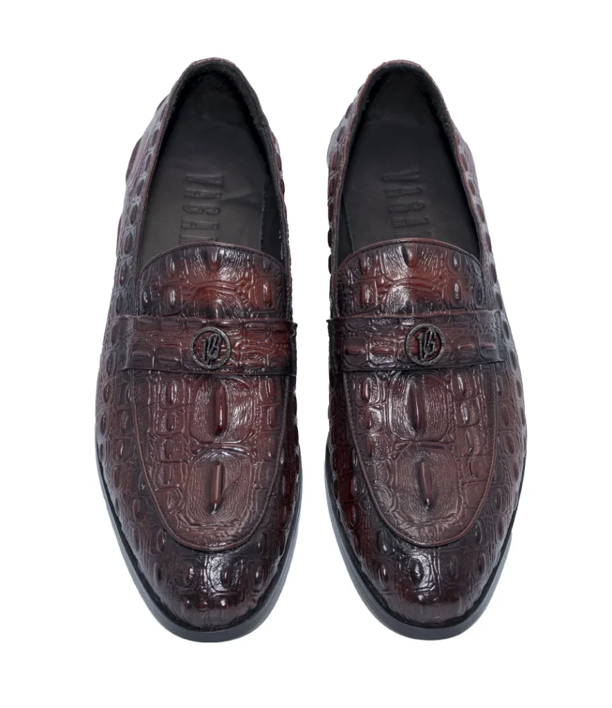 Brown men’s loafers with rich crocodile texture and a sleek metallic strap.